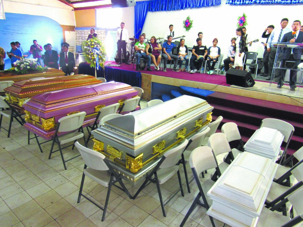 La familia sobreviviente junto a los ataúdes de sus padres, hermano, cuñada y sobrinos respectivamente en el oficio religioso antes de ir a sepultarlos en un cementerio de Managua. Foto: Wilih Narváez