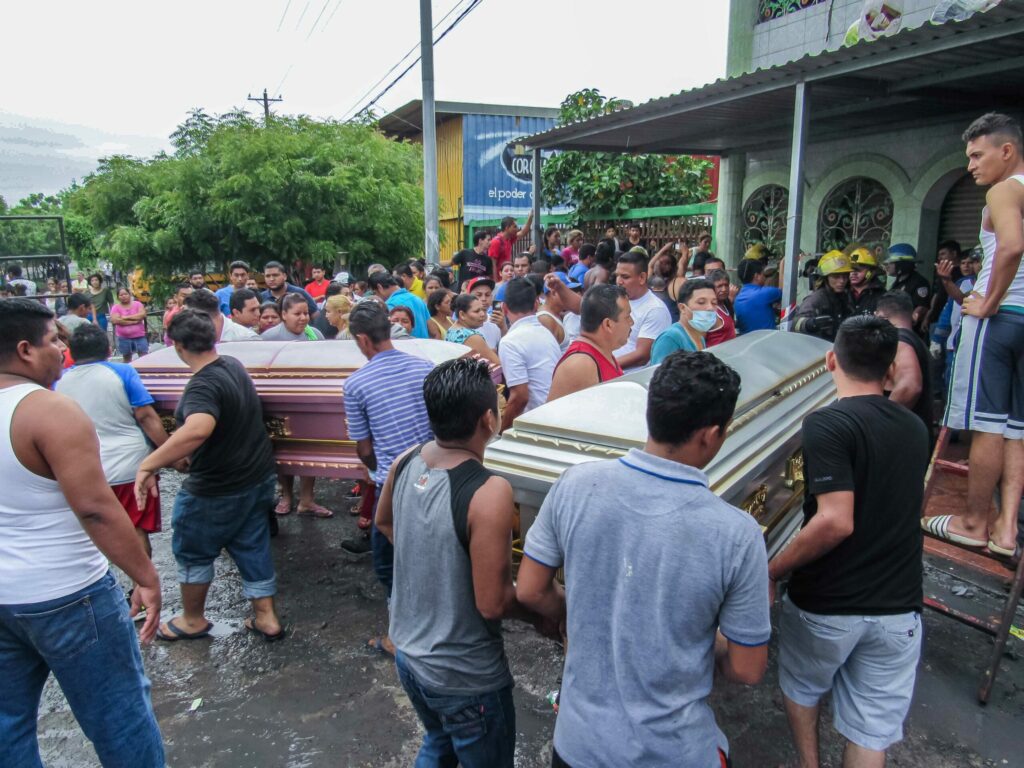 Vecinos cargan parte de los ataúdes que llevaron a la vivienda de la del barrio Carlos Marx donde seis miembros de una familia murieron calcinados por el incendio provocado por paramilitares. Foto: Wilih Narváez