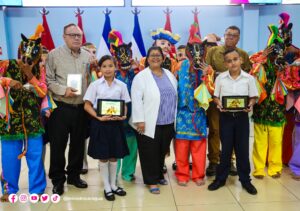 Entres símbolos partidarios de FSLN estudiantes asisten a la presentación de la presentación digital del libro: El Güegüense