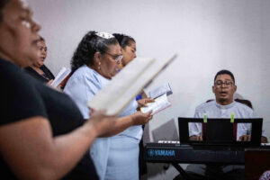 El reverendo Silva toca el órgano mientras las mujeres del coro lo acompañan con sus alabanzas|© Óscar Navarrete| Galería News