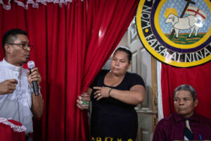 Una miembro de la iglesia le lleva un vaso de agua al reverendo durante su extenso sermón dominical|© Óscar Navarrete | Galería News